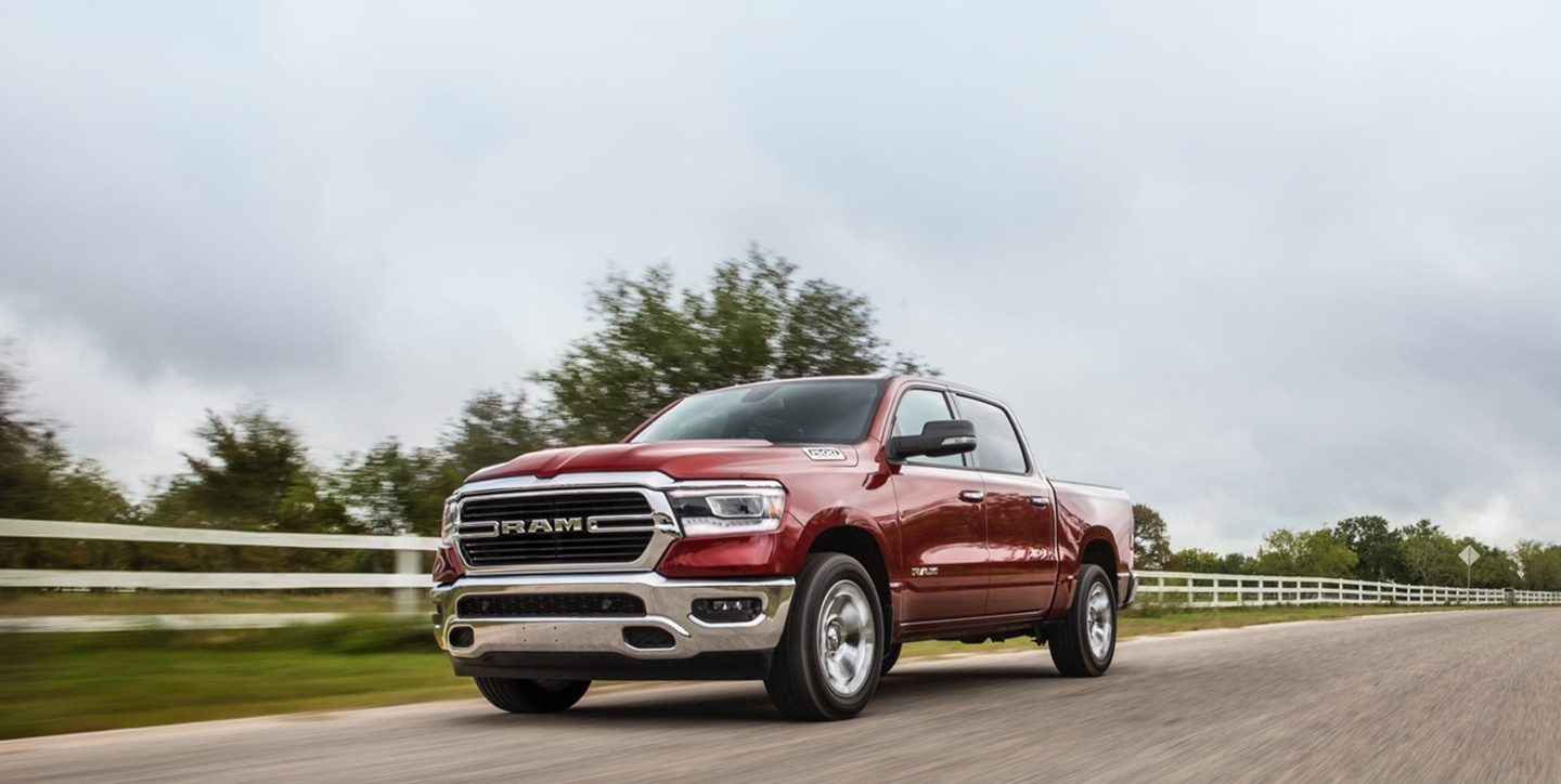 A 2020 Ram 1500 being driven on a country road.