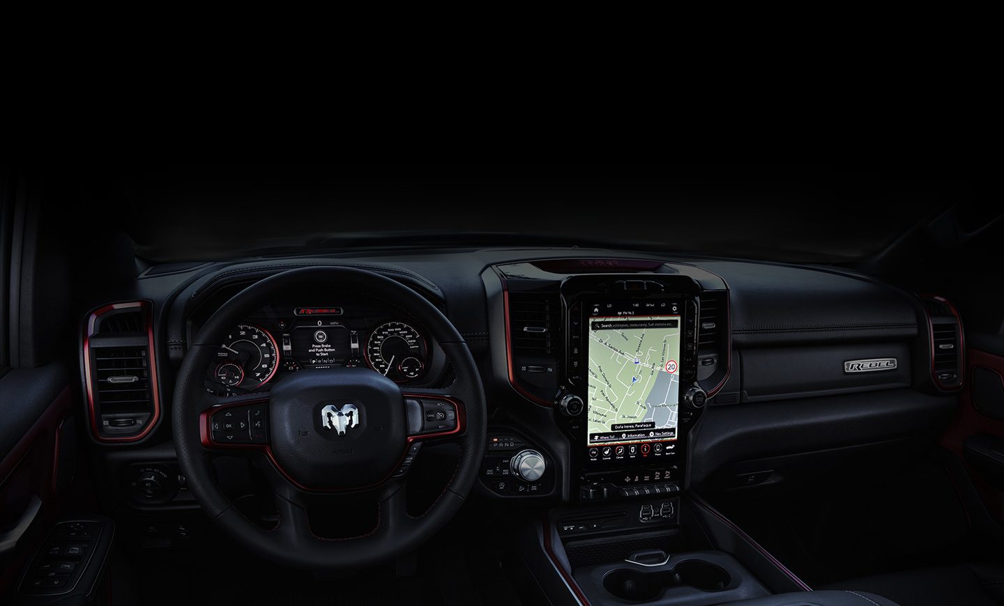 An interior view of the 2020 Ram 1500 focusing on the steering wheel and available 12-inch Uconnect 12.0 touchscreen.