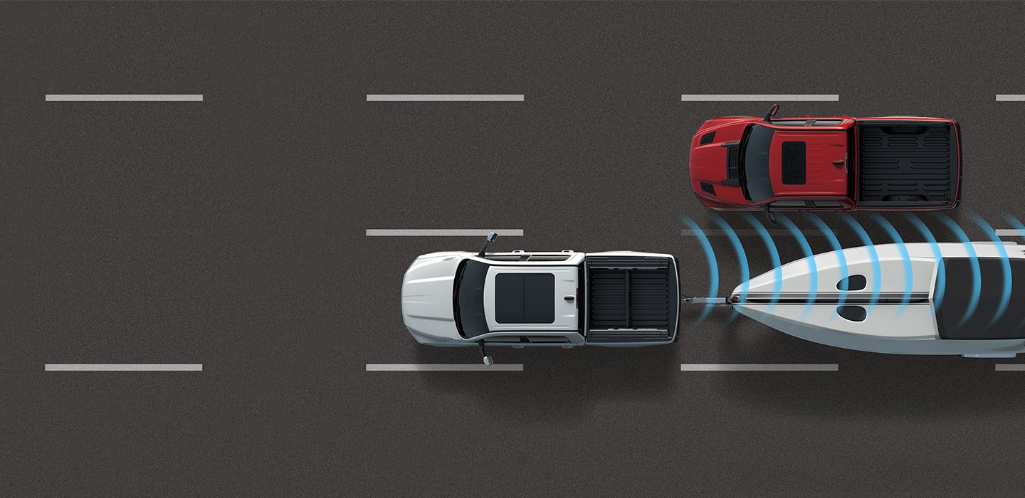 An illustration of sensors emanating from the rear of a 2020 Ram 1500 detecting another vehicle entering its blind spot zone.