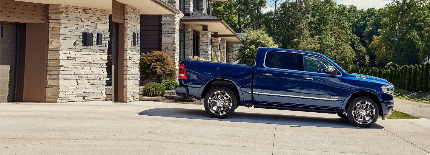 The 2022 Ram 1500 parked on a dirt road with a fenced-off field behind it.