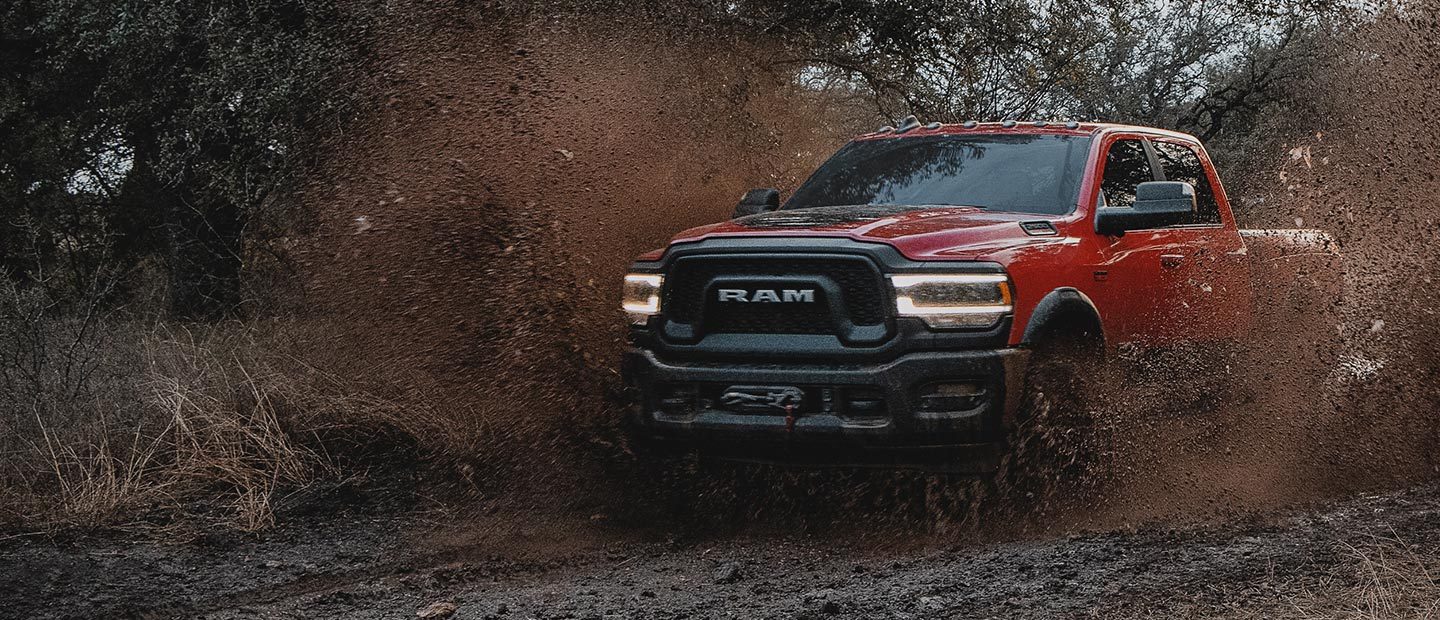 The 2022 Ram 2500 Power Wagon being driven off-road through mud.