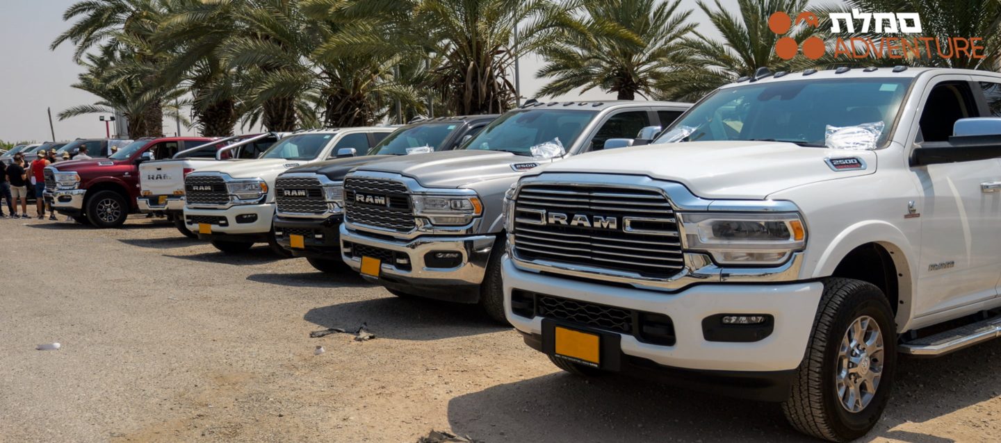 The front end of a Ram 1500 Rev with its headlamps on.