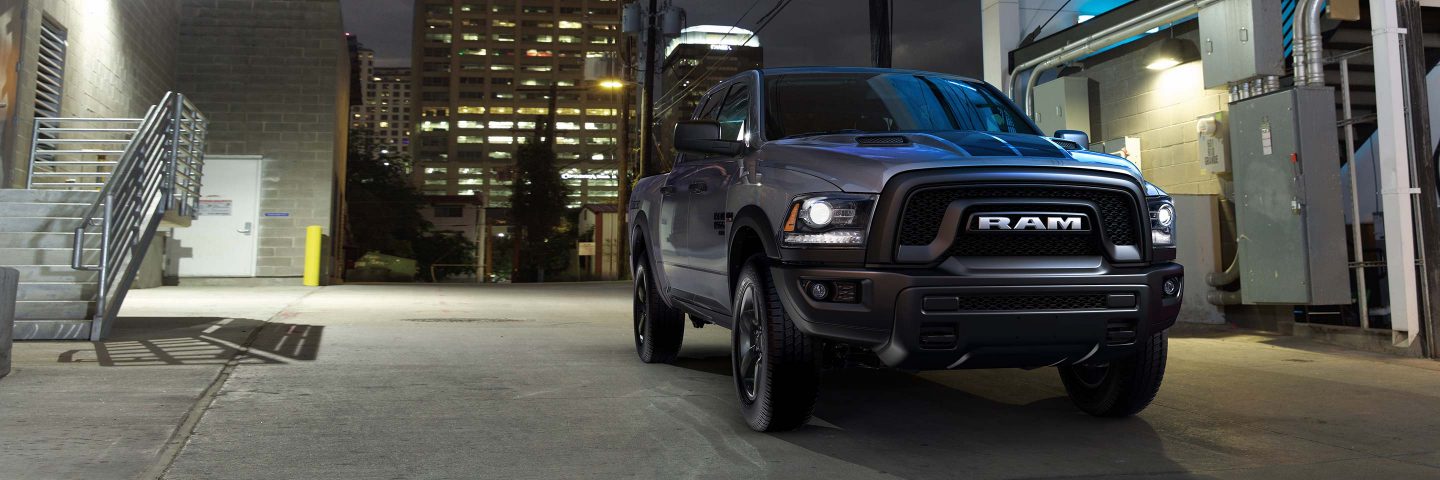 The 2022 Ram 1500 Classic parked at a loading dock with a skyscraper behind it.