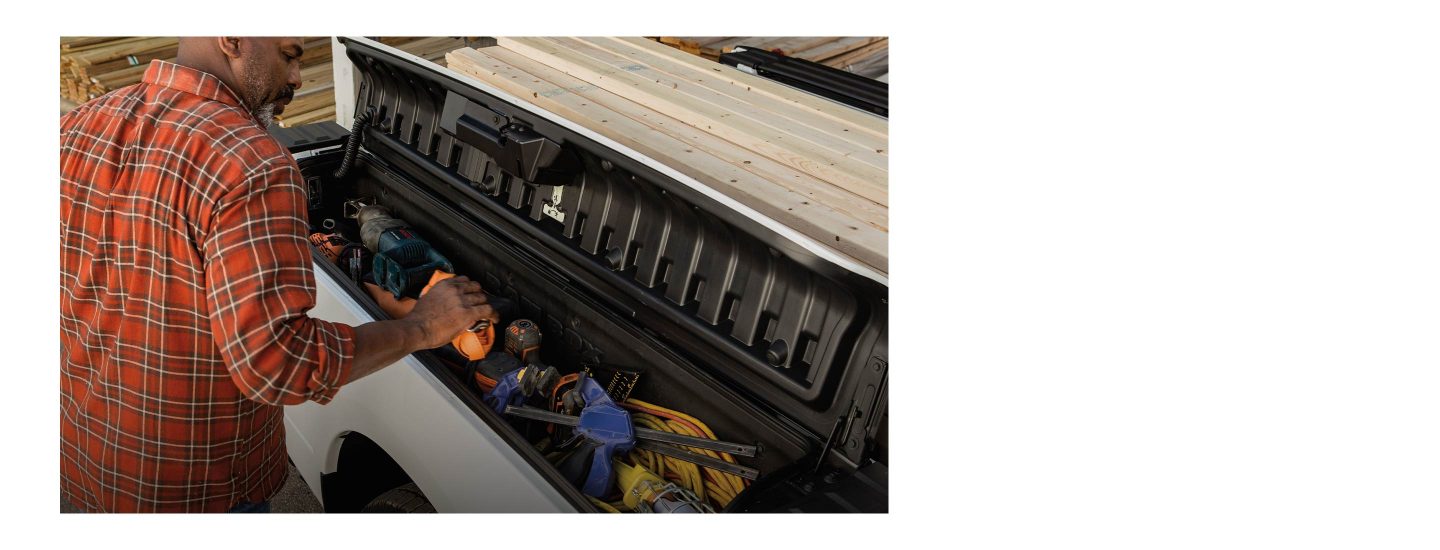 The 2022 Ram 1500 Classic with the RamBox lid open to reveal power tools and cables stored within.