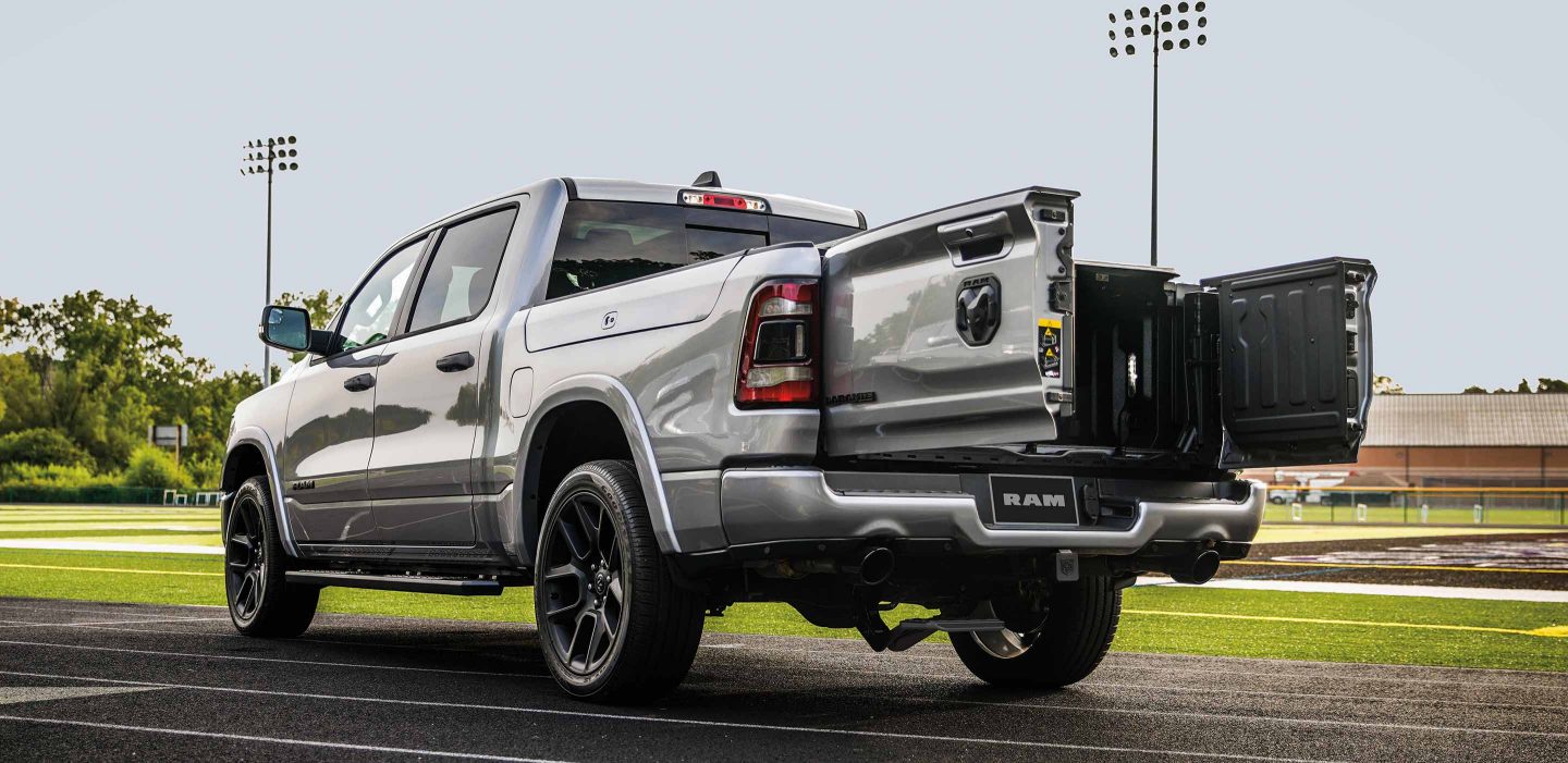Display The 2023 Ram 1500 parked on a racetrack with the swing-open tailgate doors open.