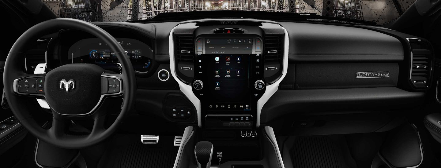 The interior of the 2023 Ram 1500 Laramie G/T focusing on the steering wheel and Uconnect touchscreen.