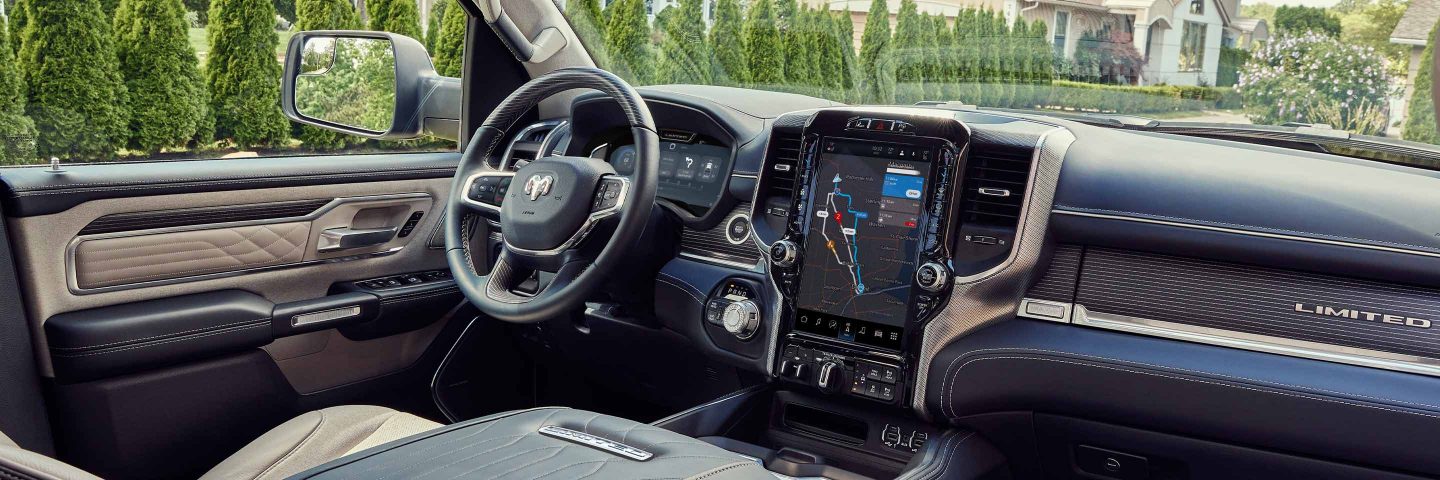 El interior de una Ram 1500 2023 con la gran pantalla táctil Uconnect que muestra un mapa de navegación.