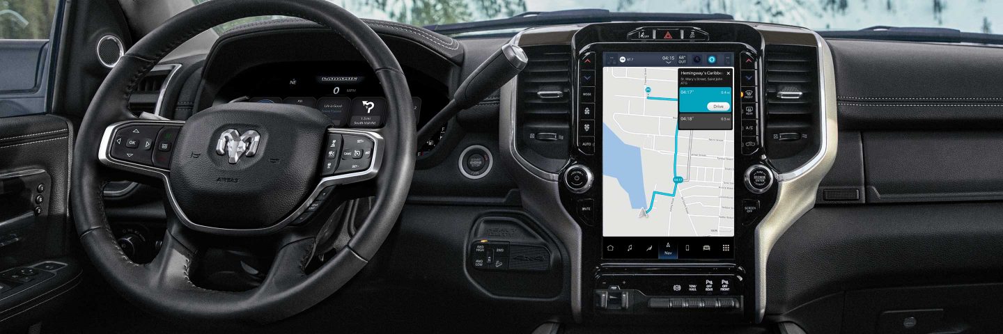 El volante y la pantalla táctil Uconnect de la Ram 3500 Laramie 2023, con la pantalla mostrando un mapa de navegación.