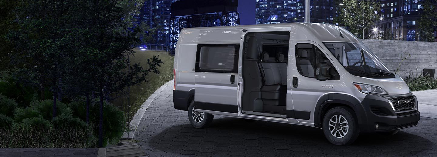 The 2023 Ram ProMaster 2500/3500 Cargo Crew Van High Roof with its side door open to reveal a second row of seats.