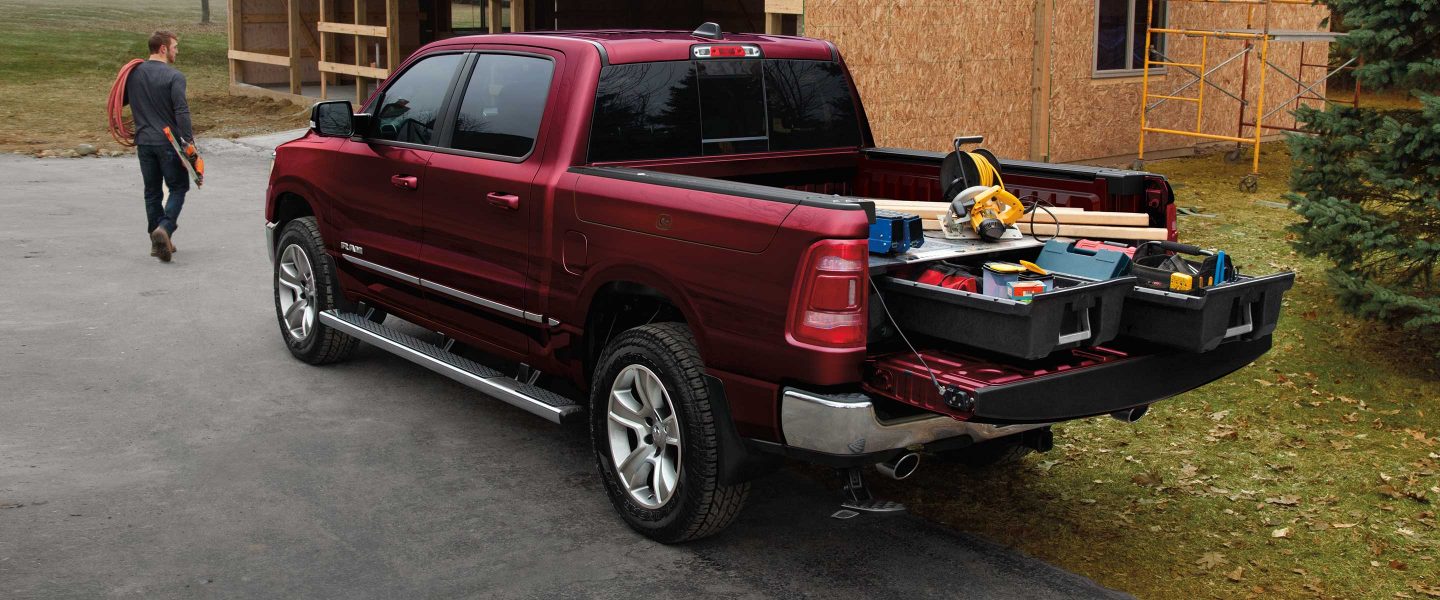 La Ram 1500 con la puerta trasera hacia abajo para mostrar la plataforma de la camioneta equipada con cajones deslizables llenos de herramientas y equipos de construcción.