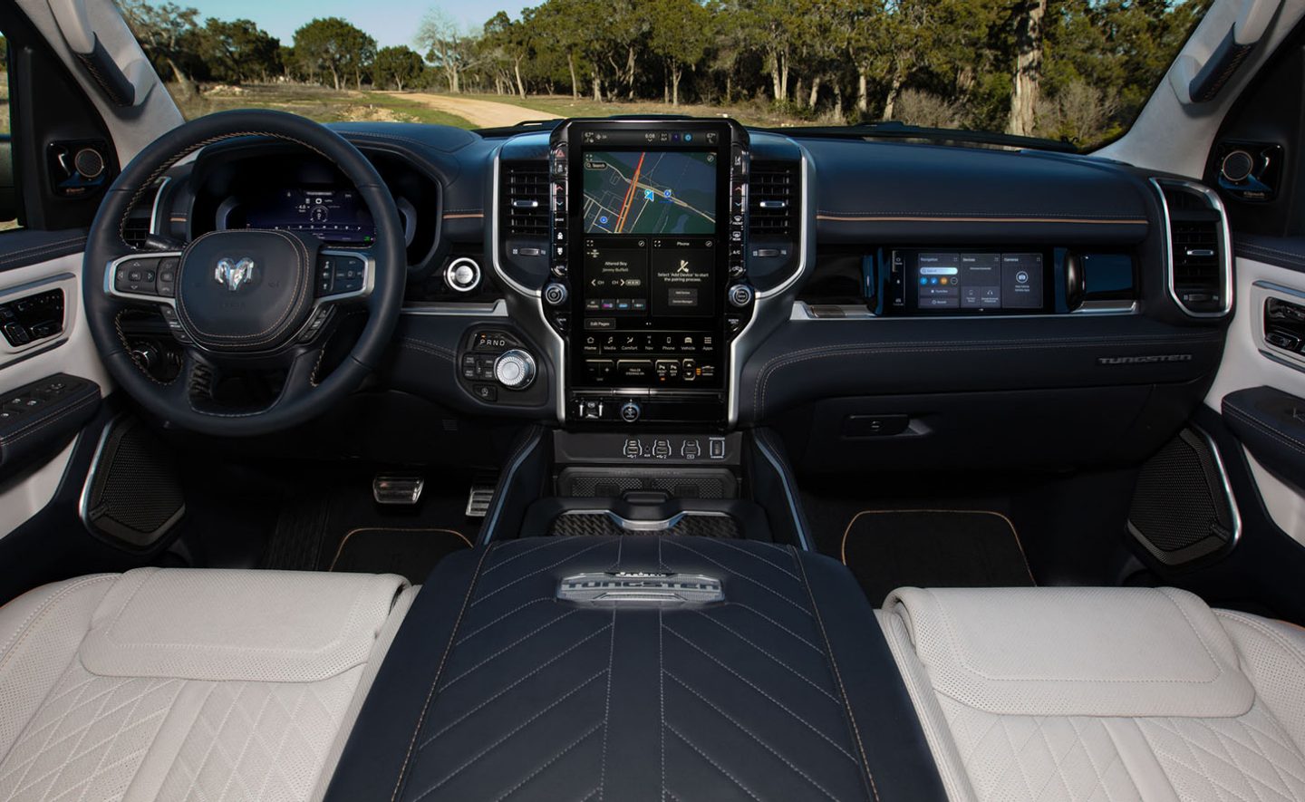 El volante, la pantalla digital de información para el conductor en el panel de instrumentos, la pantalla táctil de Uconnect y la pantalla táctil interactiva para el pasajero delantero en la Ram 1500 Tungsten 2025.