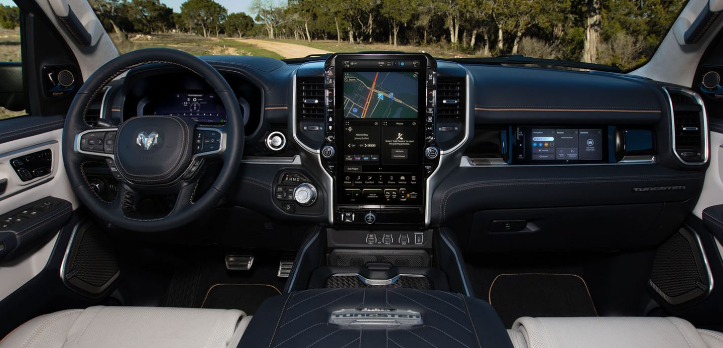 The steering wheel, Driver Information Digital Cluster, Uconnect touchscreen and front Passenger Interactive Touchscreen Display in the 2025 Ram 1500 Tungsten.