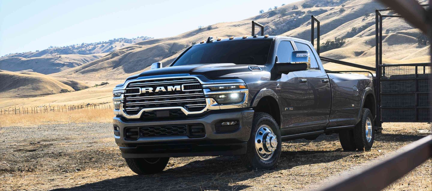 Una Ram 3500 Limited Longhorn Crew Cab gris estacionada en un rancho ganadero en el desierto.