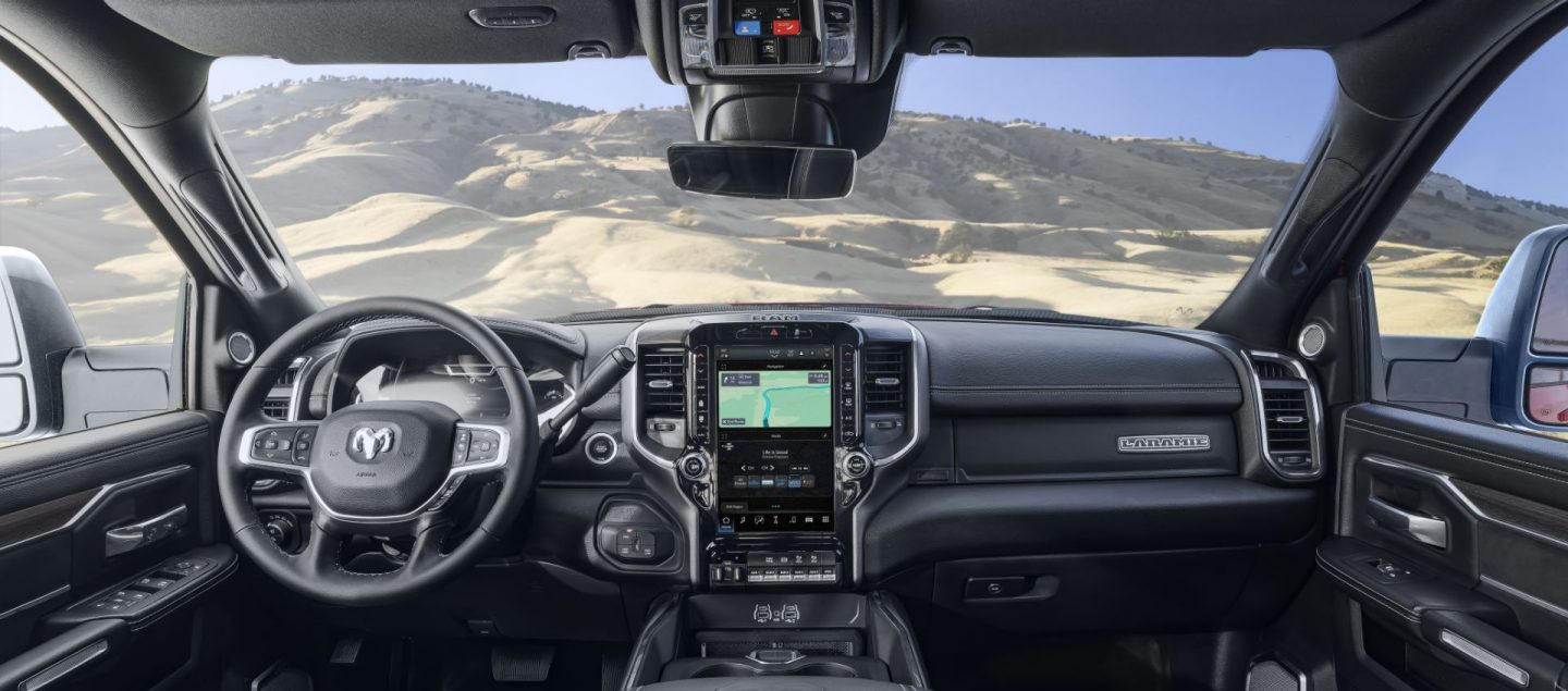 El interior de una Ram 5500 Laramie Chassis Cab 2025 desde la perspectiva del conductor, en la cual se muestra a través del parabrisas que la camioneta está en un desierto.