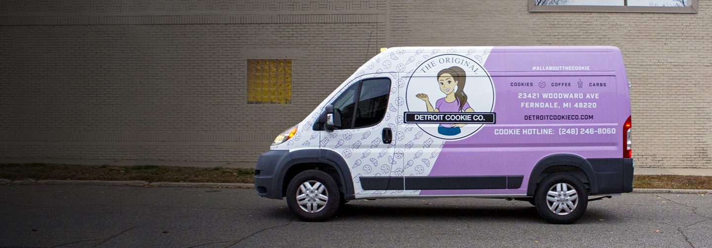 Profile view of the Detroit Cookie Company Ram ProMaster van parked on the street.