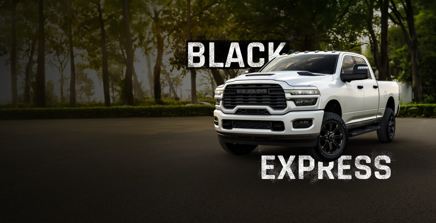 Toma frontal en ángulo de una Ram 2500 Black Express Crew Cab 2026 en un parque. Black Express.