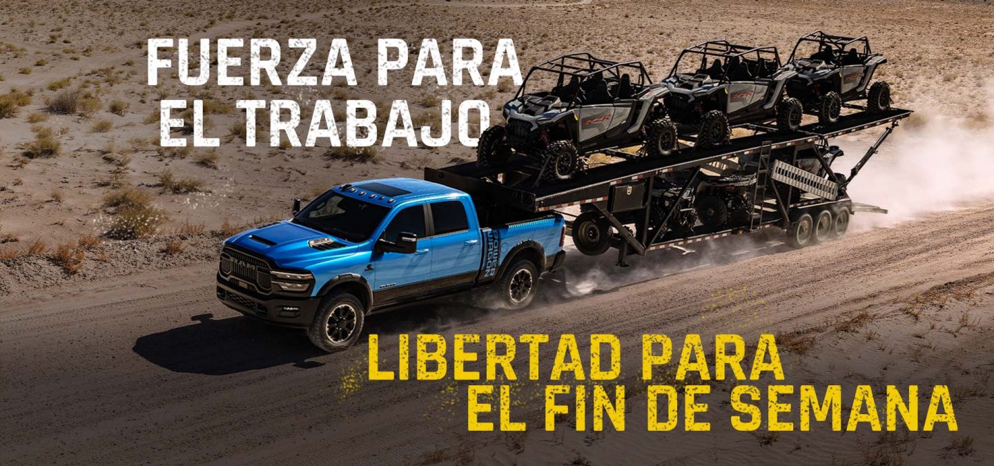 Una pick up de trabajo pesado Ram 2500 Power Wagon 4x4 Crew Cab de color azul circulando por una carretera del desierto, remolcando cinco vehículos todoterreno en un tráiler tipo cuello de ganso. Potencia para el trabajo. Libertad para el fin de semana.