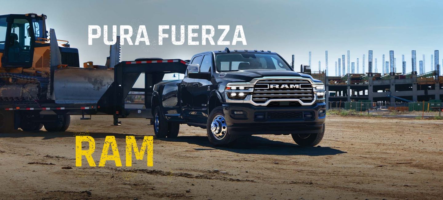 Una pick up de trabajo pesado Ram 3500 Laramie 4x4 Crew Cab 2027 de color negro remolcando maquinaria de construcción en una obra industrial. Pon la fuerza en acción.