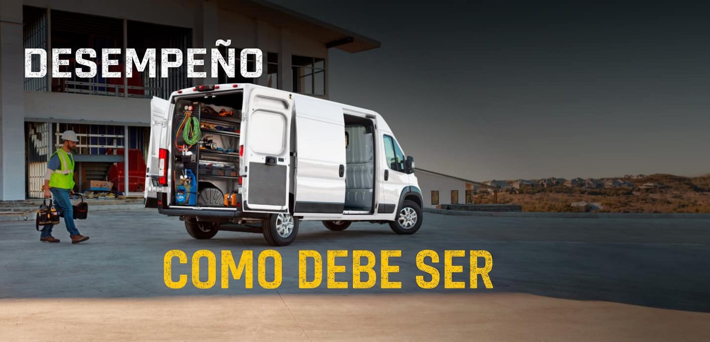 La parte trasera de una Ram ProMaster 2500 SLT High Roof Cargo Van 2027 blanca con la puerta deslizable del lado del pasajero y las puertas traseras abiertas por las cuales se observan estantes llenos de herramientas y un técnico caminando hacia la van. Desempeño como debe ser.