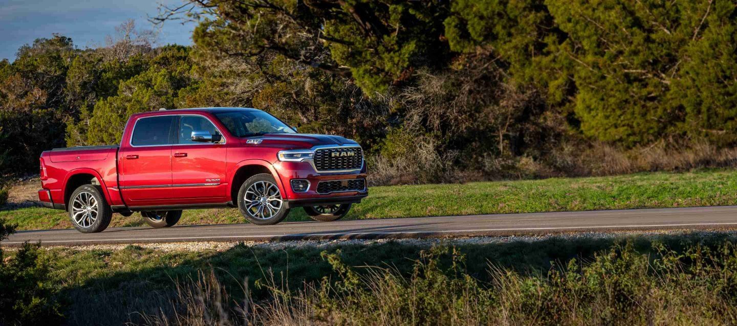 A black 2023 Ram 1500 Laramie 4x4 Crew Cab parked on a clearing in the desert at dusk. It's Ram season.
